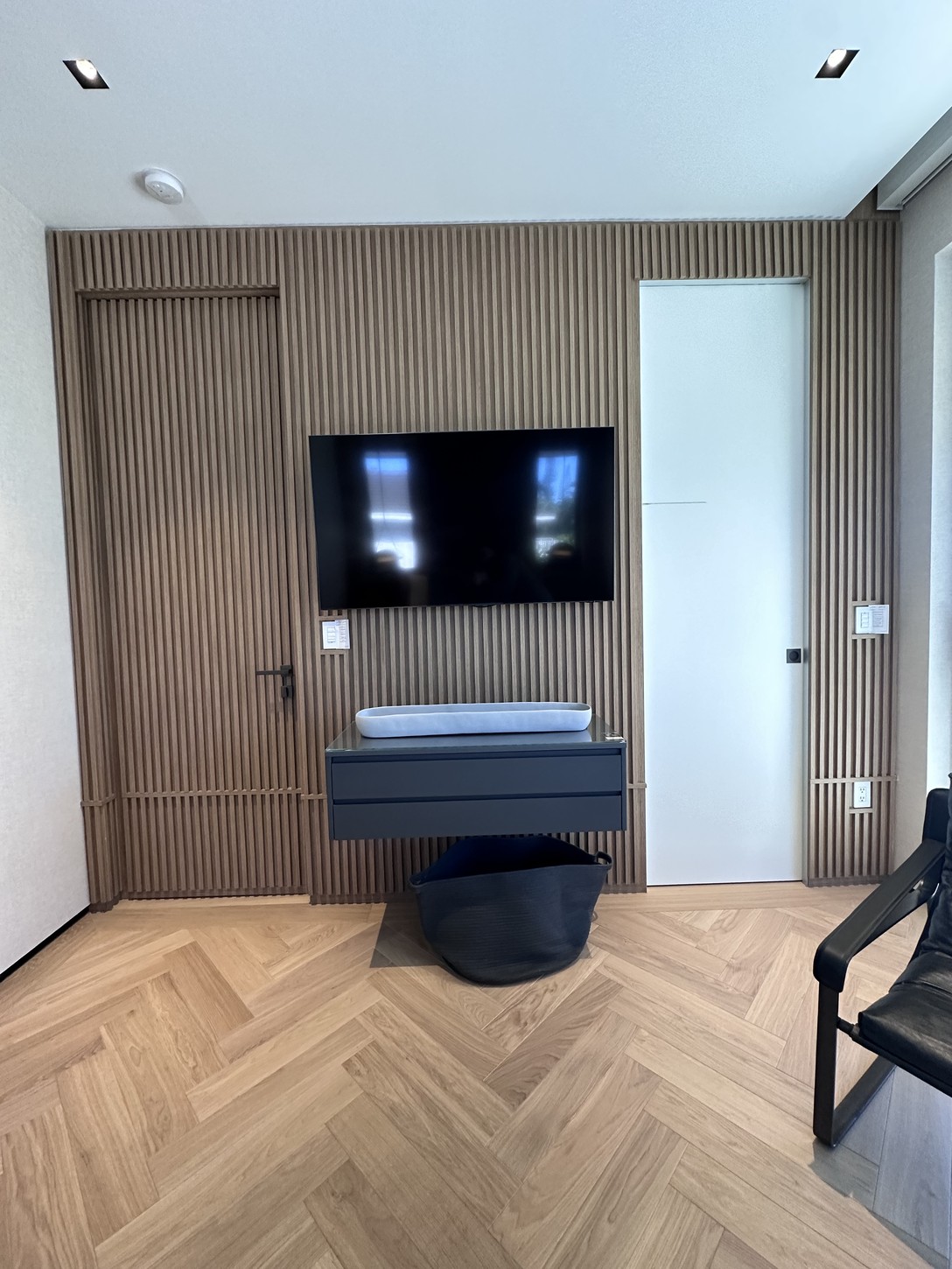 Wood-slat television wall with floating cabinet in a Coral Gables residence