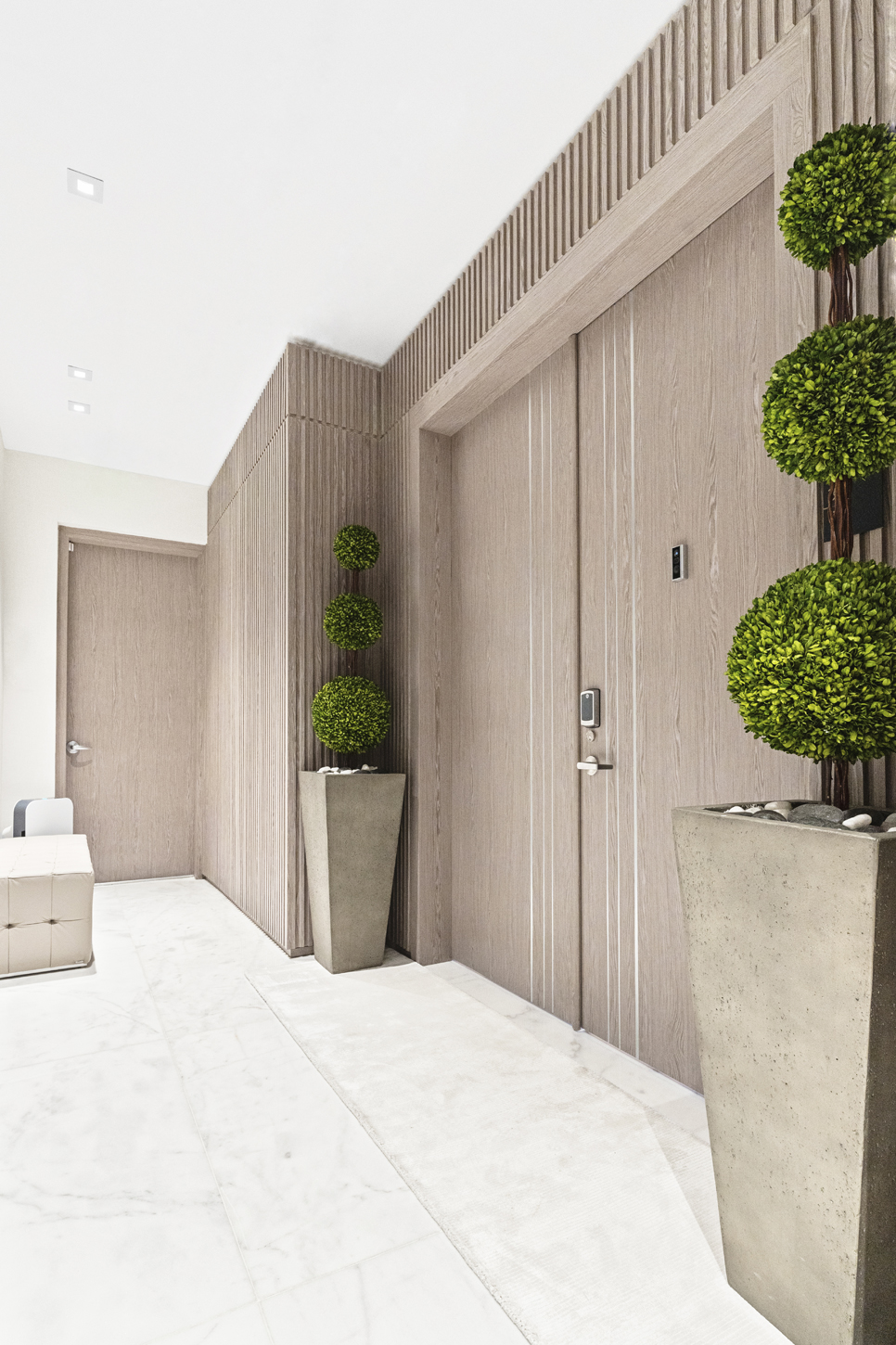 Entryway with custom wood-paneled doors and architectural wall detailing