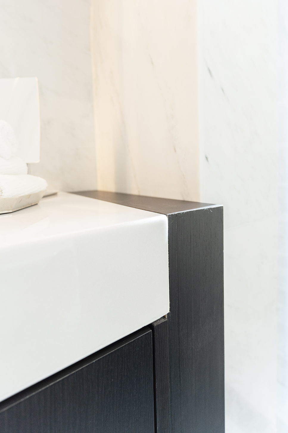 Close-up detail of custom bathroom vanity with marble countertop and wood cabinetry