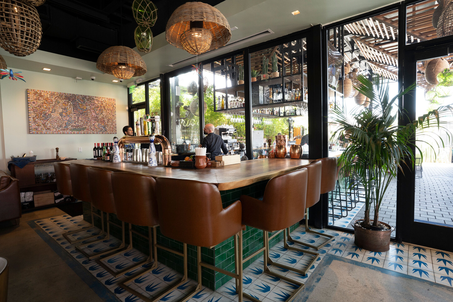 Wynwood restaurant millwork: custom bar with a green subway tile front and rattan pendant lights at Bakan in Miami