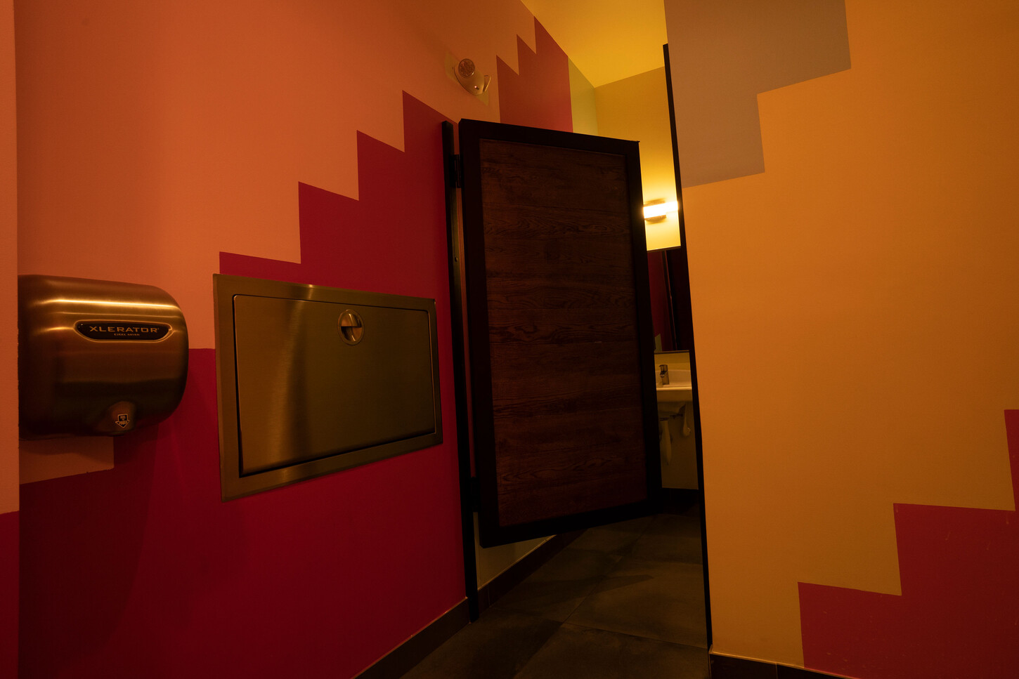 Custom restroom wood veneer door with stainless steel detail at Bakan Wynwood in Miami