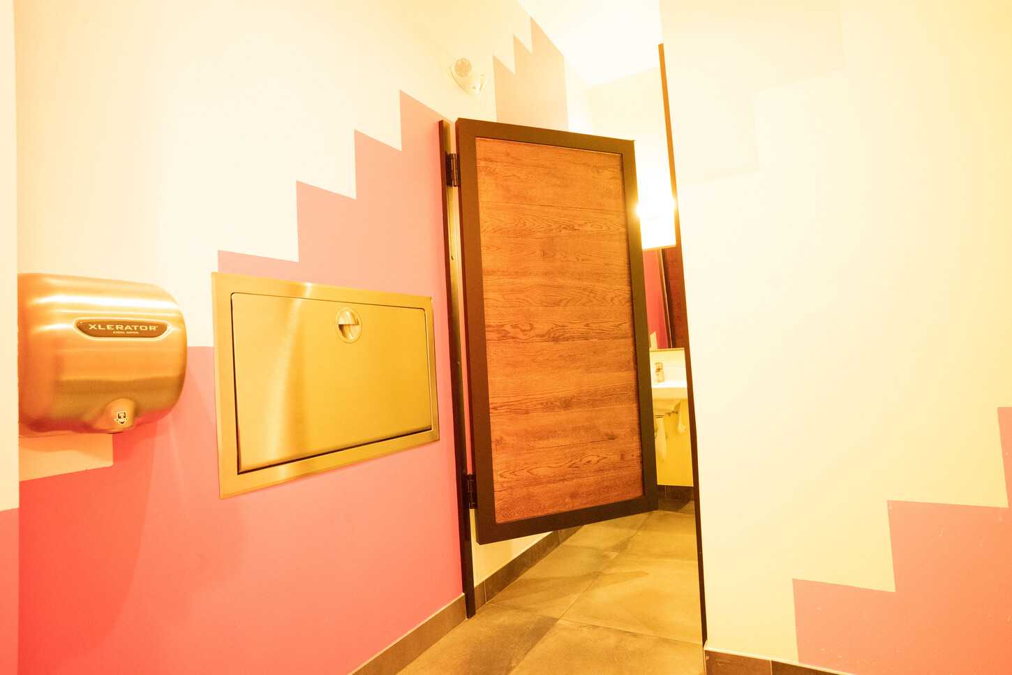 Restroom entry with a custom millwork door at Bakan Wynwood restaurant in Miami, Florida