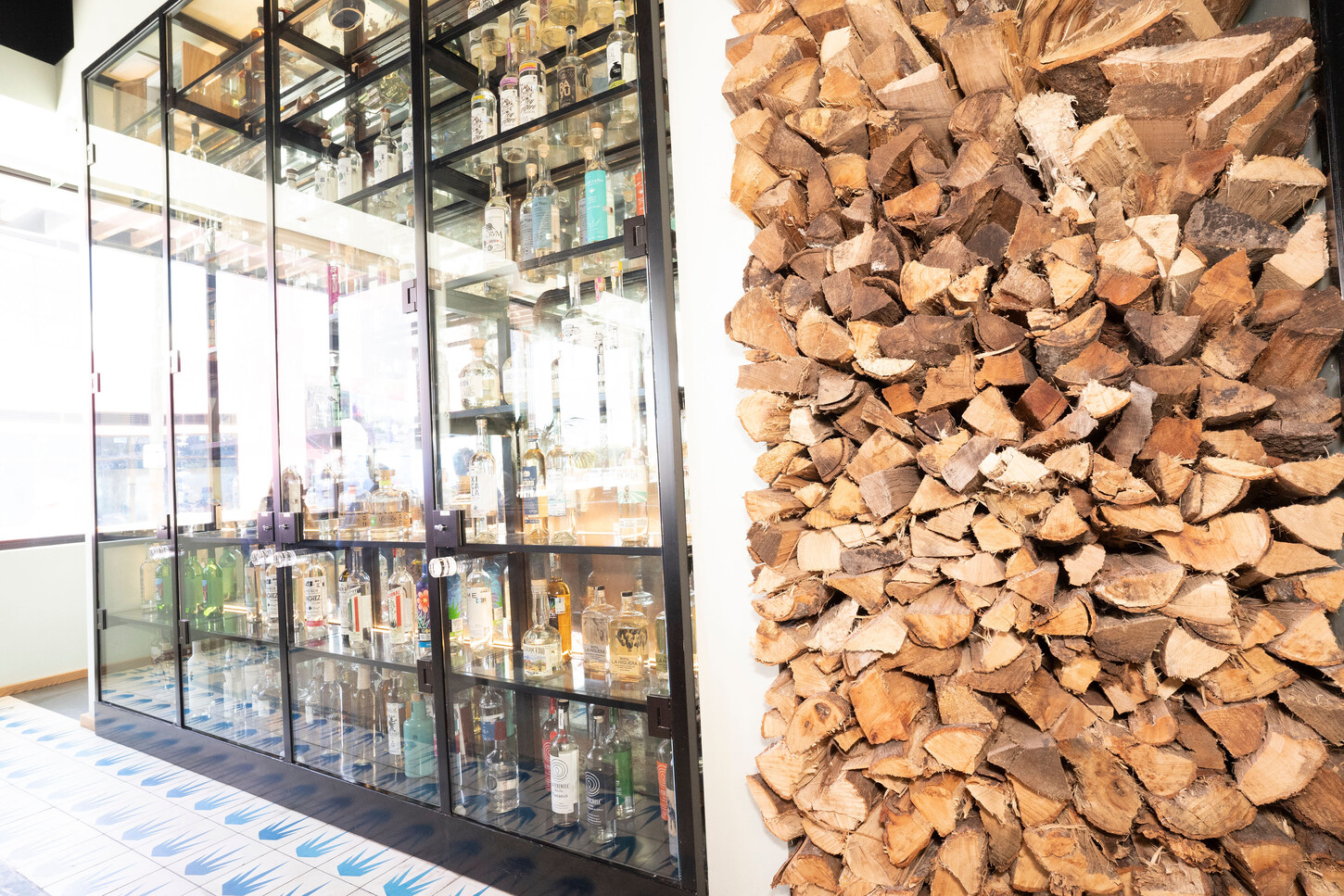 Custom fabricated cabinet against a firewood accent wall at Bakan in Wynwood, Florida