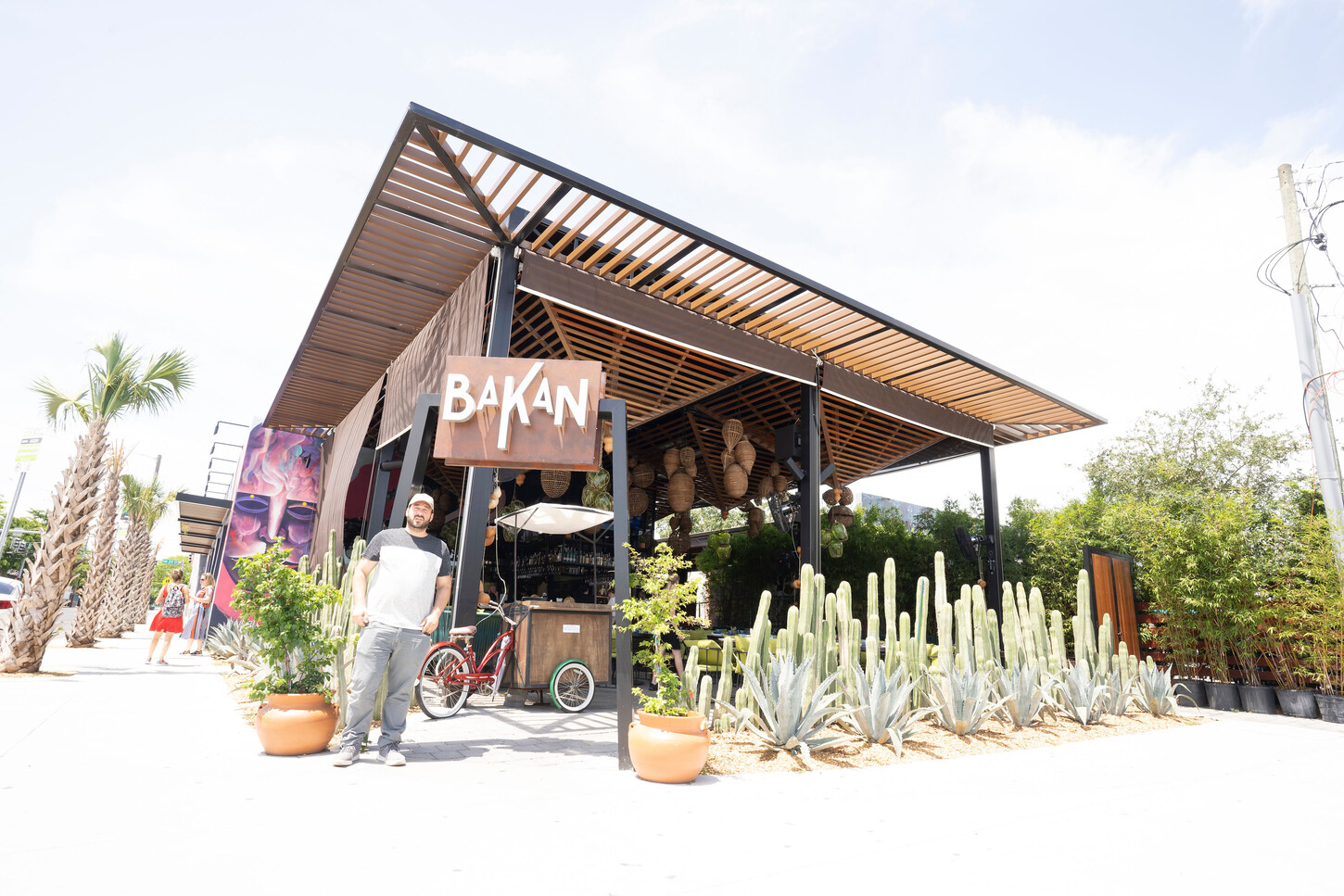 Restaurant exterior with a wood pergola and cactus landscaping at Bakan in Wynwood, Florida