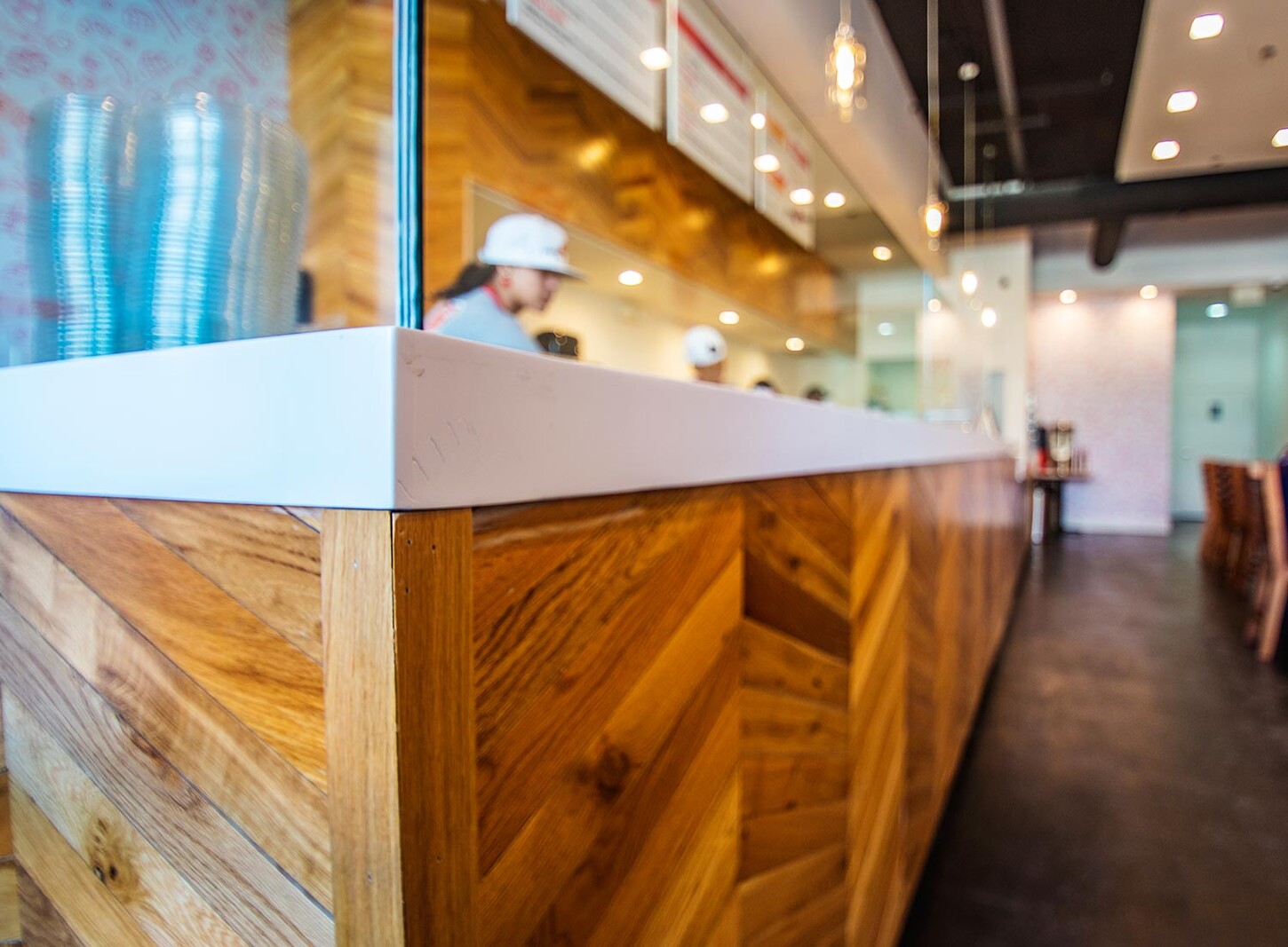 Wynwood restaurant millwork: custom chevron wood counter front with white countertop at Crazy Poke in Miami