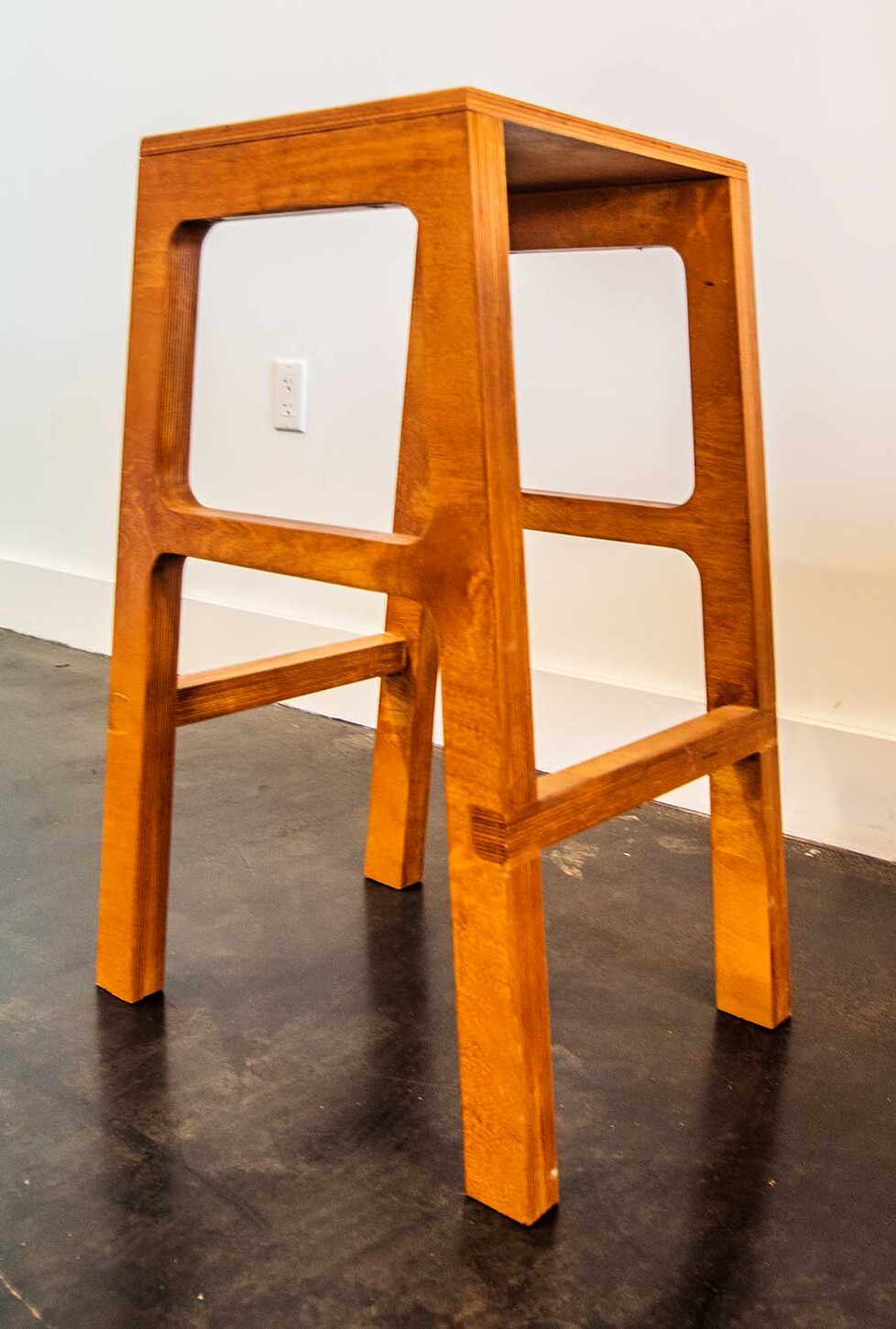 Custom open-frame wood bar stool, side view, for a Miami restaurant