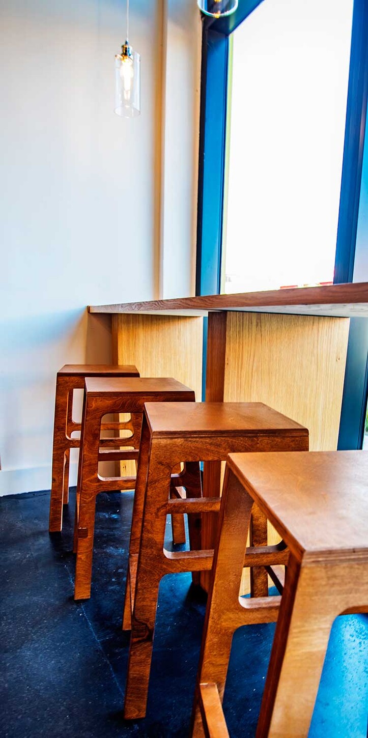 Custom wood bar stools at a window counter in a Wynwood restaurant