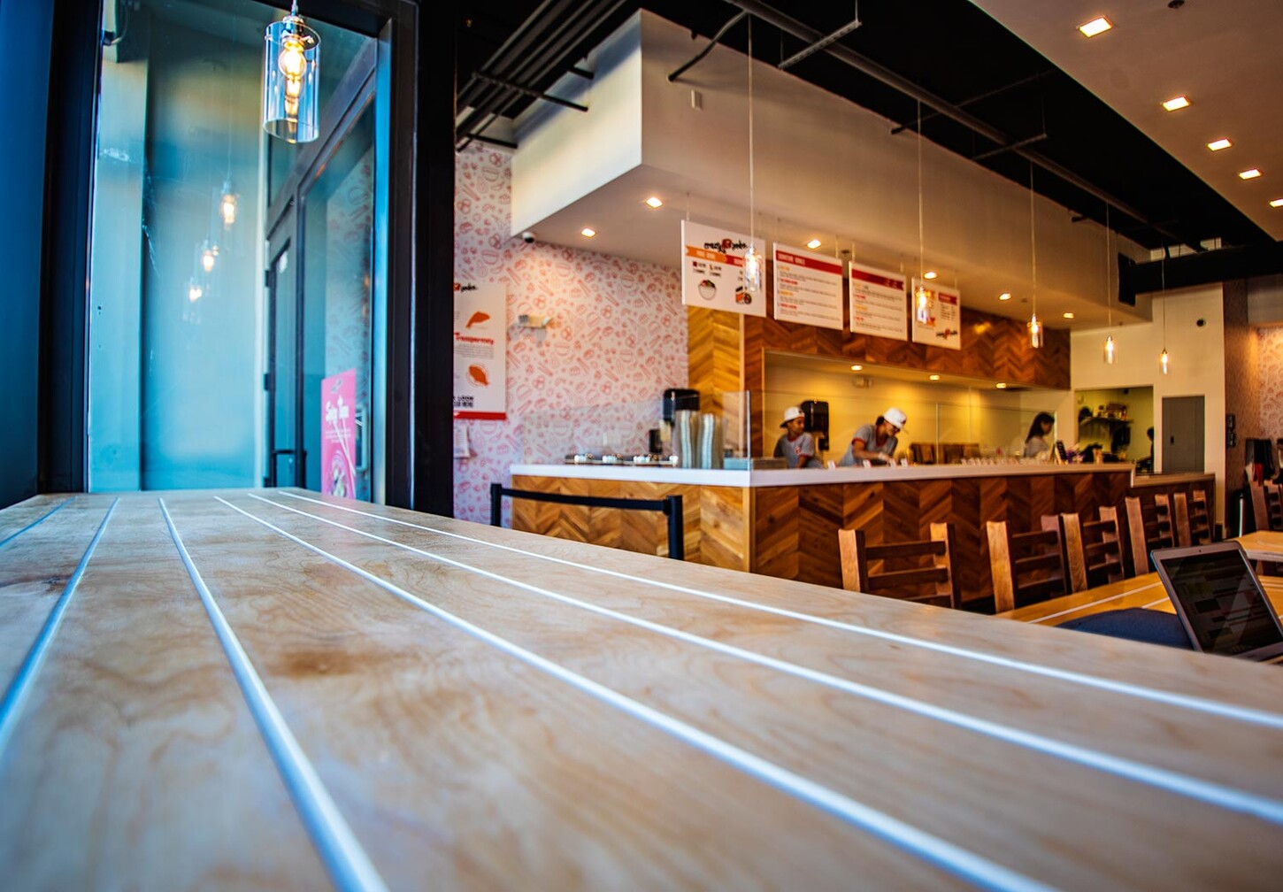 Custom wood table top with white inlay lines in a Miami restaurant