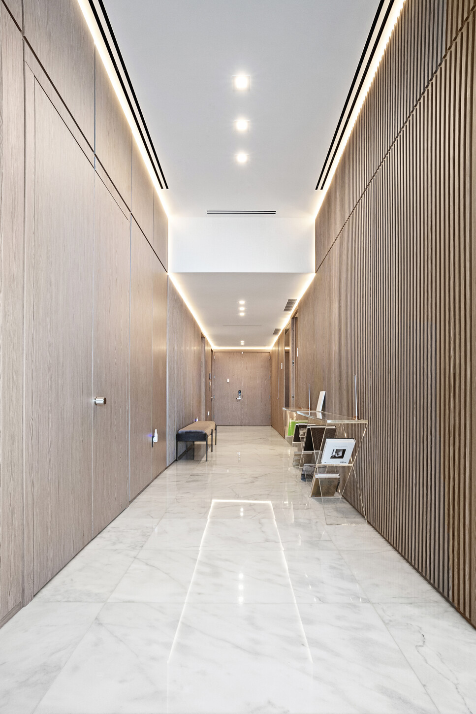 Custom wood wall paneling along a hallway in a Sunny Isles, Miami residence by CM Custom Design.