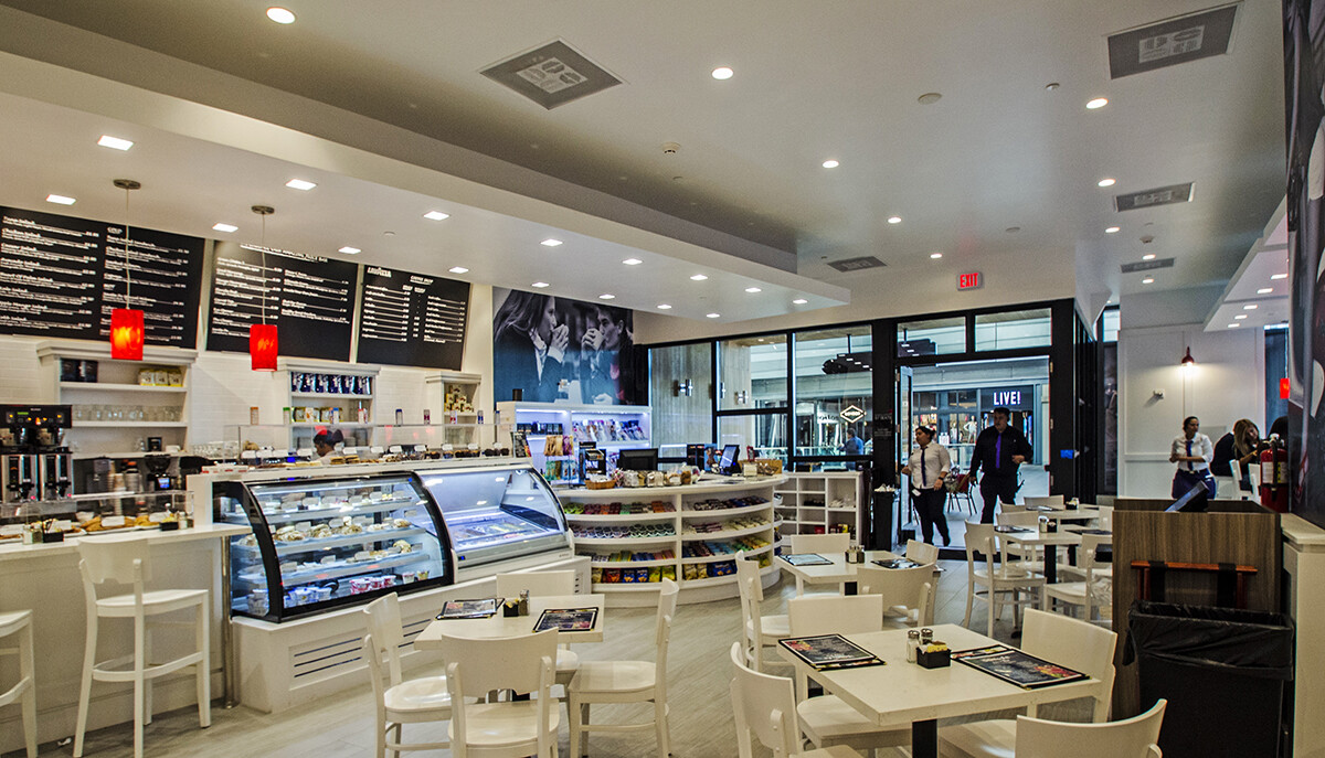 Brickell coffee shop dining area with white millwork, a pastry case, and round display shelving in Miami