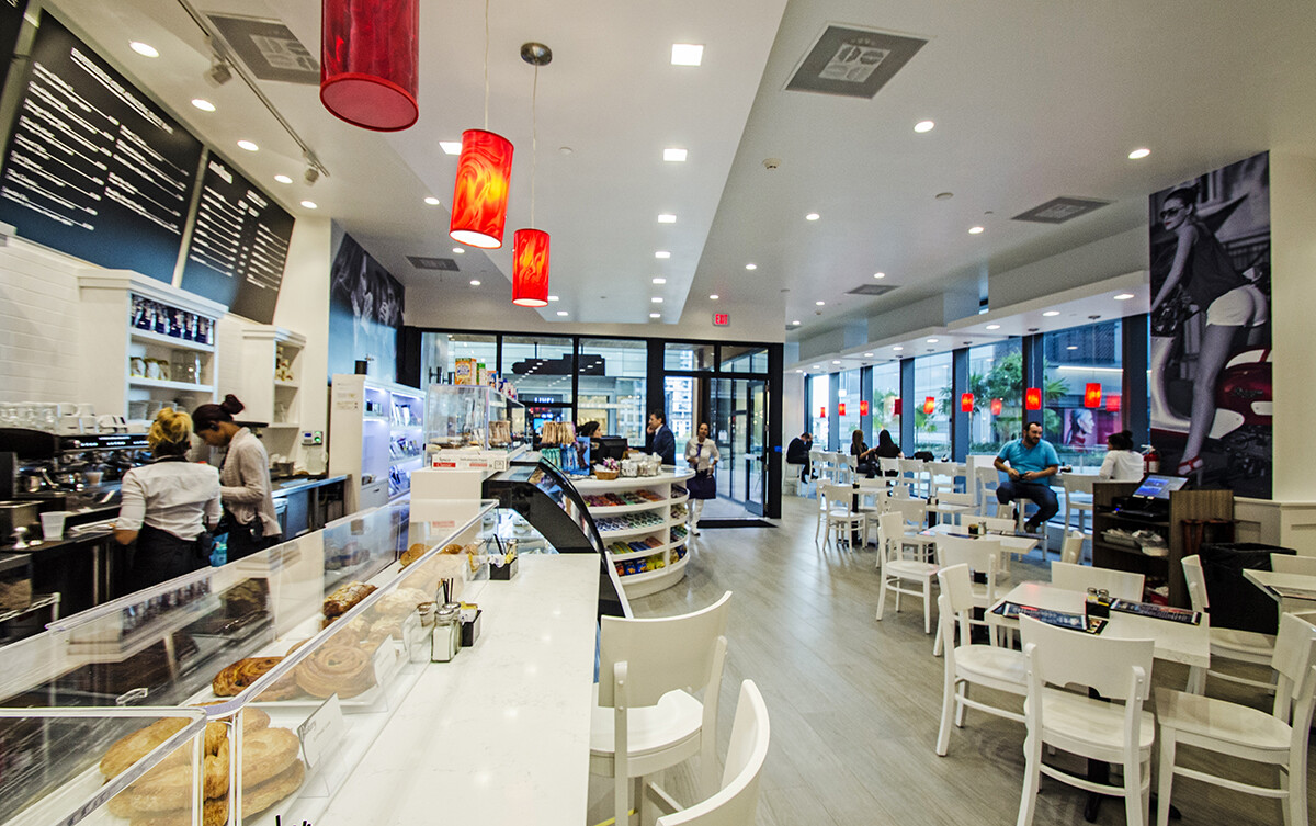 Pastry display counter and seating area in a Brickell coffee shop with custom millwork in Miami
