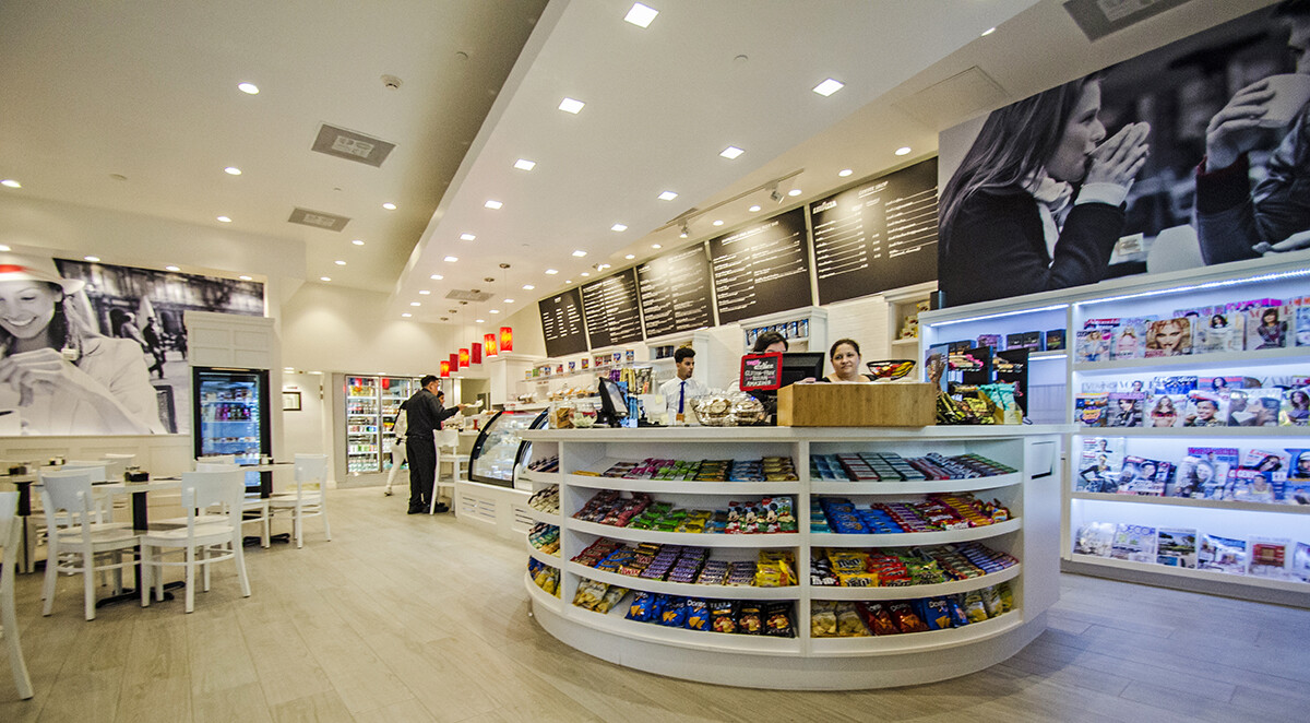Custom millwork Brickell: round display counter with open shelving for merchandise inside a Miami coffee shop