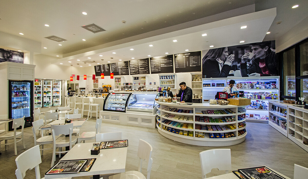 Wide view of the round shelving display and white custom millwork in a Brickell coffee shop, Miami