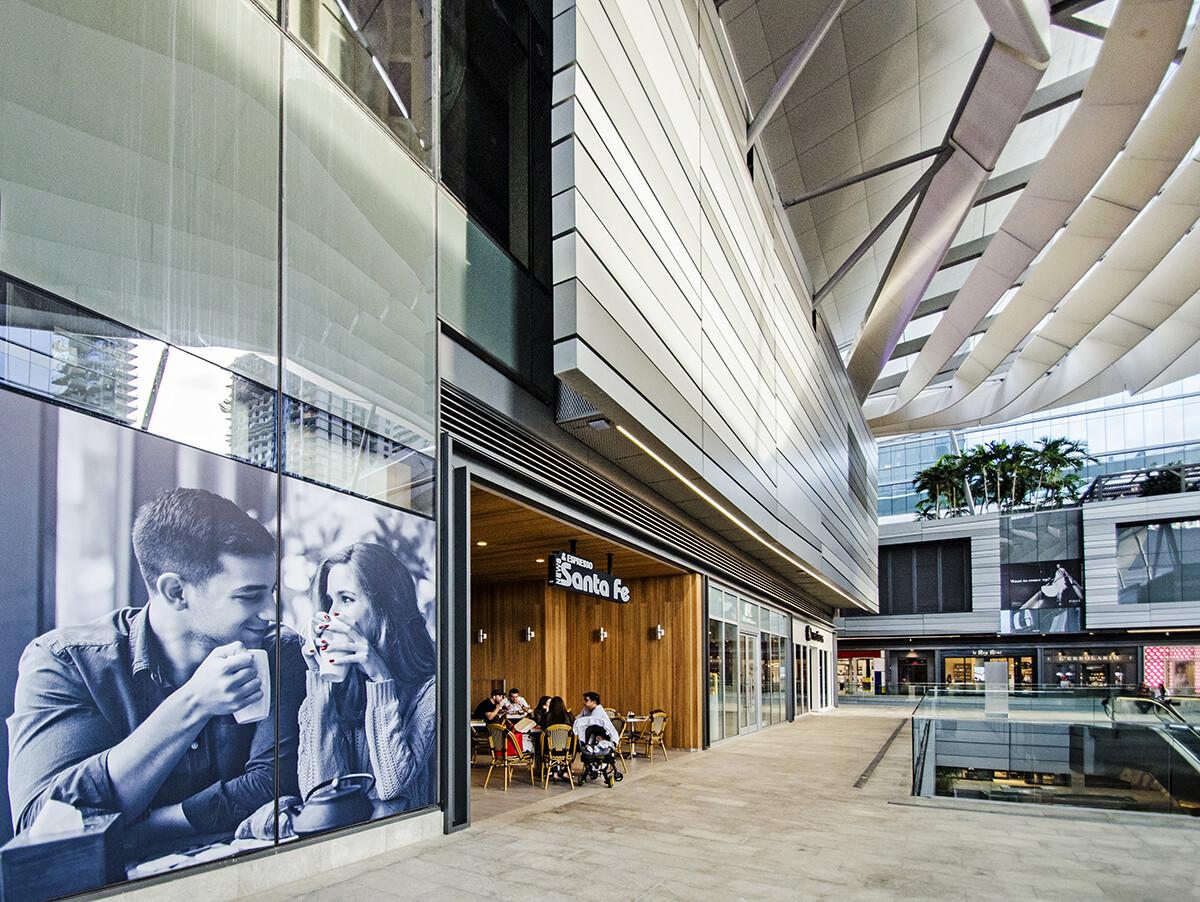 Storefront entrance of a Brickell coffee shop in Miami with a black and white photo mural and a warm wood interior