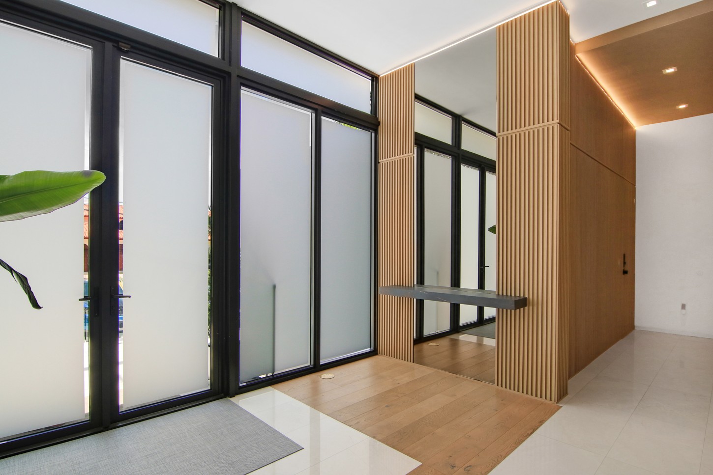Entry foyer wood slat wall with floating stone shelf in North Miami