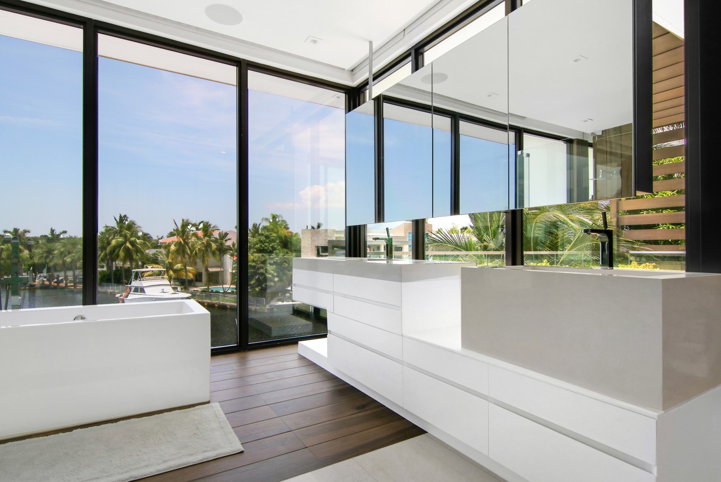 Master bathroom with a custom floating vanity and freestanding tub overlooking the water in North Miami