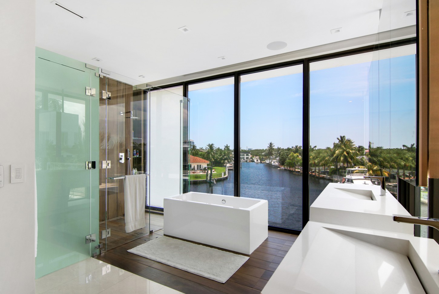 Glass shower beside a custom floating vanity in a North Miami master bathroom