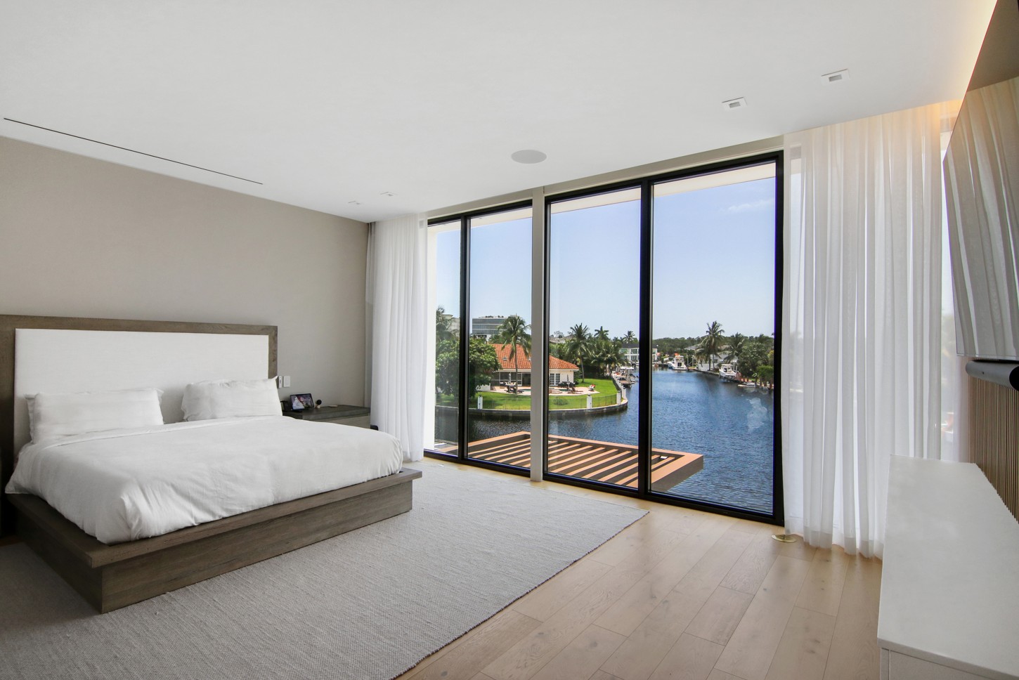 Master bedroom with custom woodwork and a waterfront view in North Miami