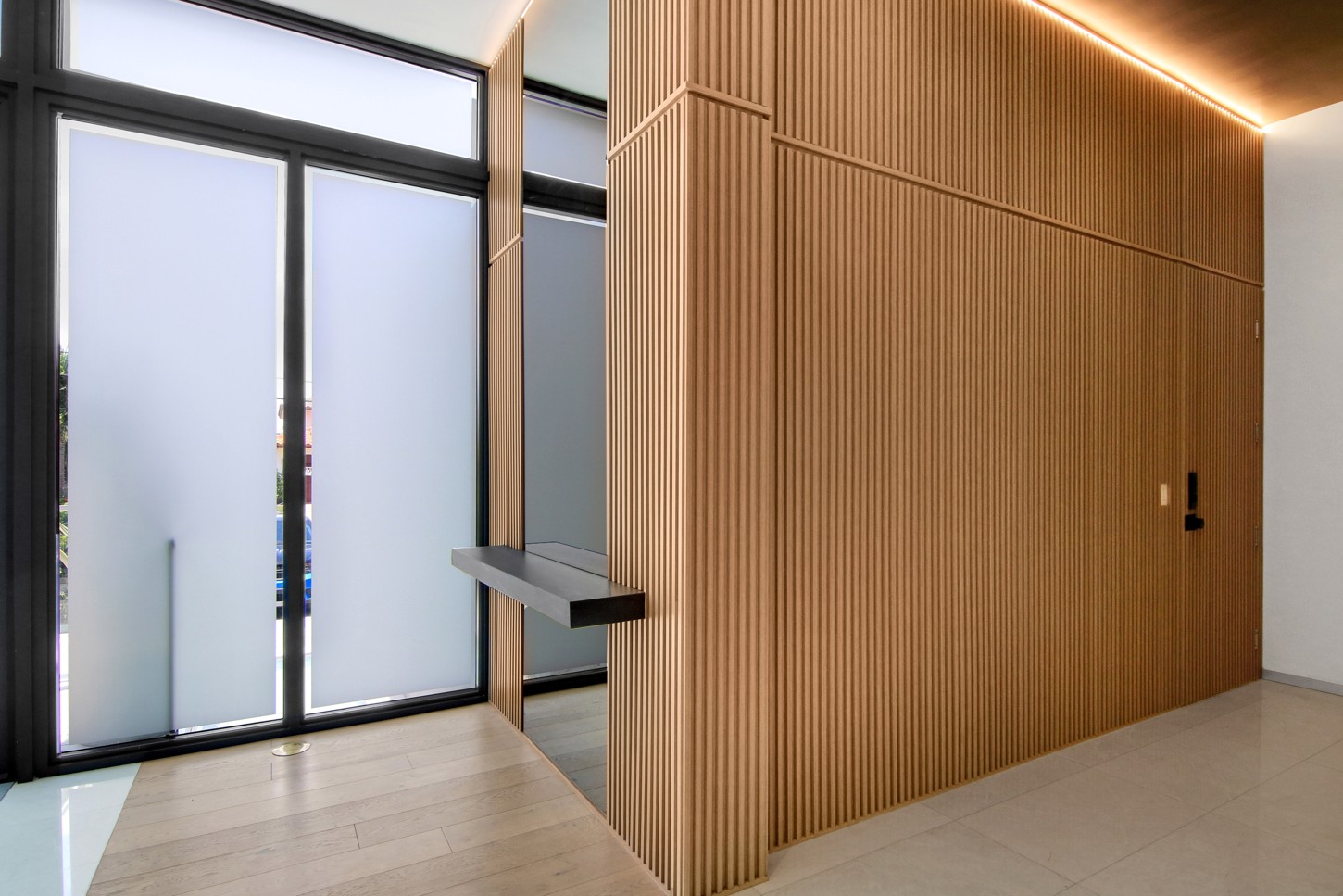 Wood panel wall with concealed door and LED lighting in a North Miami home