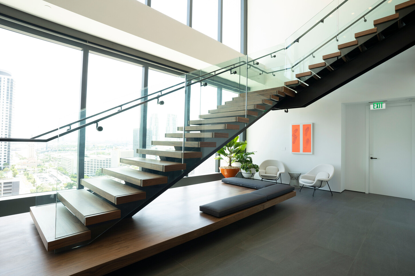 Floating wood staircase on a black steel stringer with city views, custom millwork by CM Custom Design in Miami