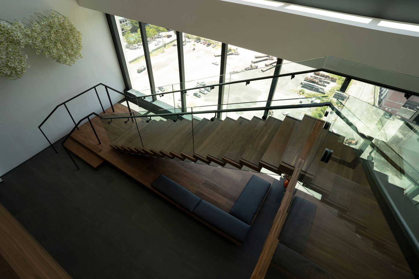 Overhead view of floating staircase wood treads and glass railing in a Miami high-rise