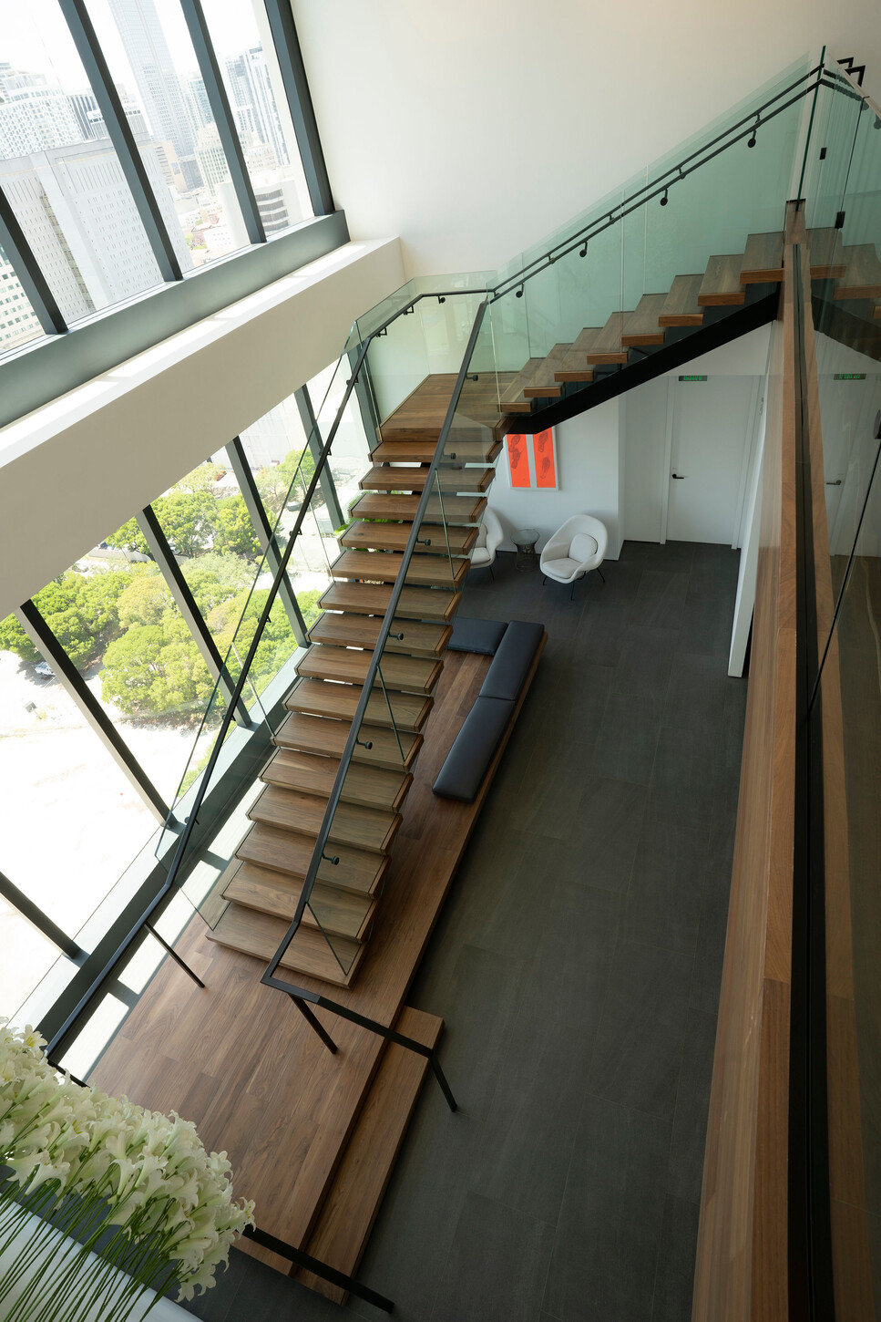 Floating staircase wood handrail and glass panels seen from above in a Miami high-rise