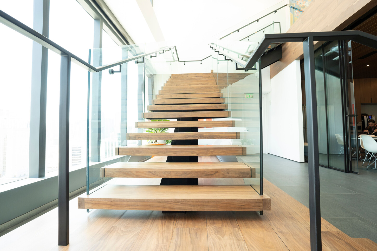 Front view of a floating wood staircase with glass balustrade in a Miami high-rise