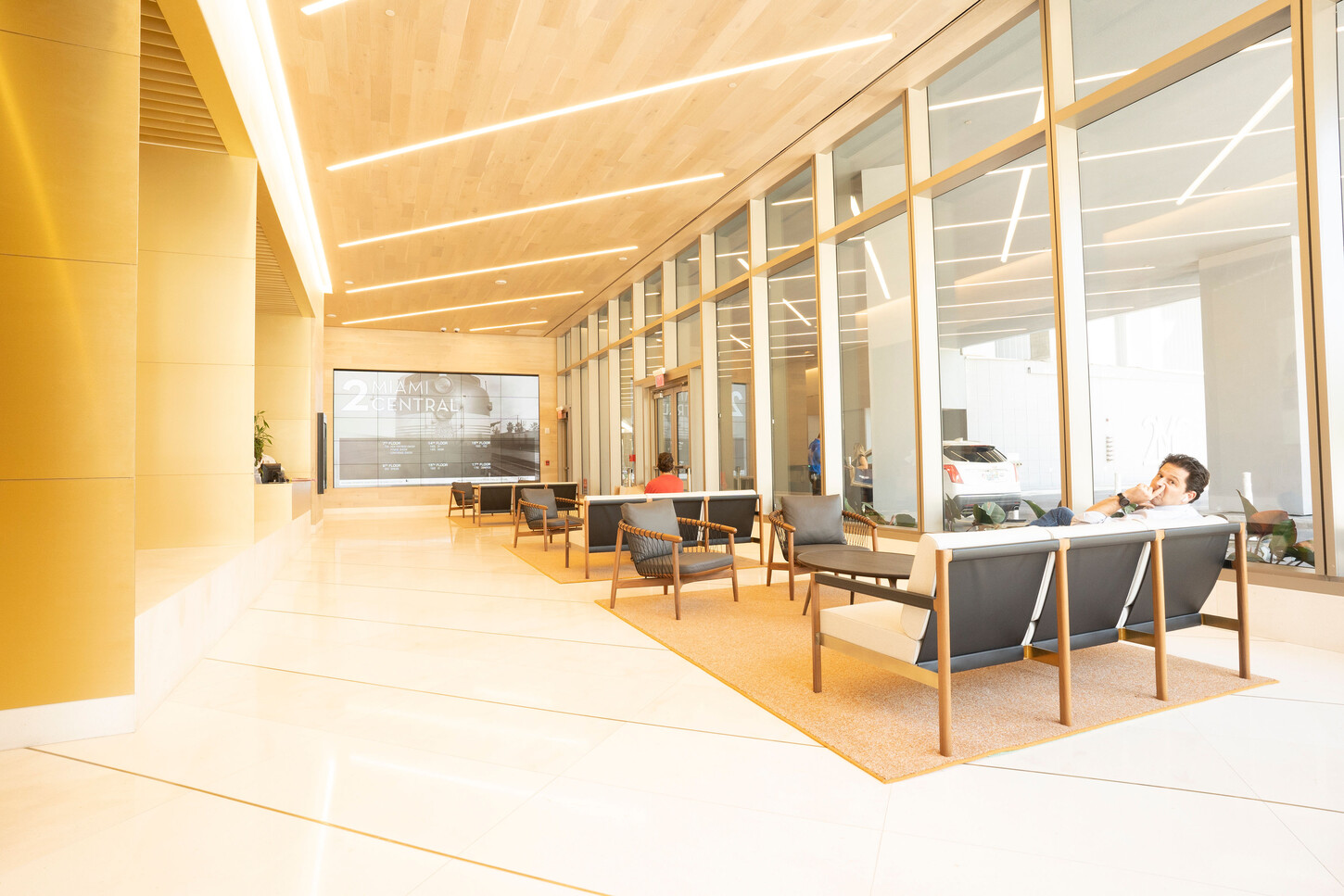 Wood-paneled ceiling and lobby seating area with floor-to-ceiling glass in a Miami high-rise