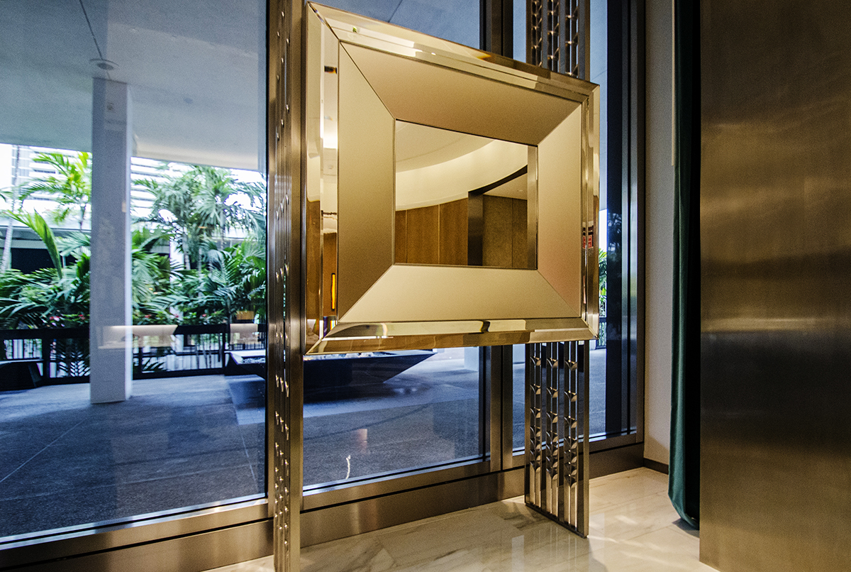 Custom bronze-toned glass and mirror entrance element with metal detailing at the Tiffany boutique, Bal Harbour Shops