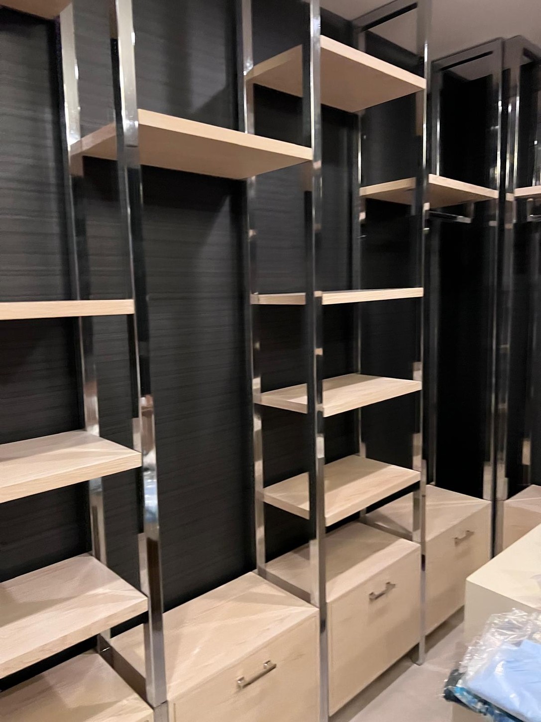 Custom spa shelving units with wood veneer shelves and polished metal uprights