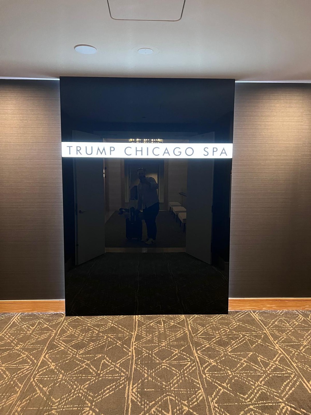 Illuminated Trump Chicago Spa sign on black glass at the spa entrance