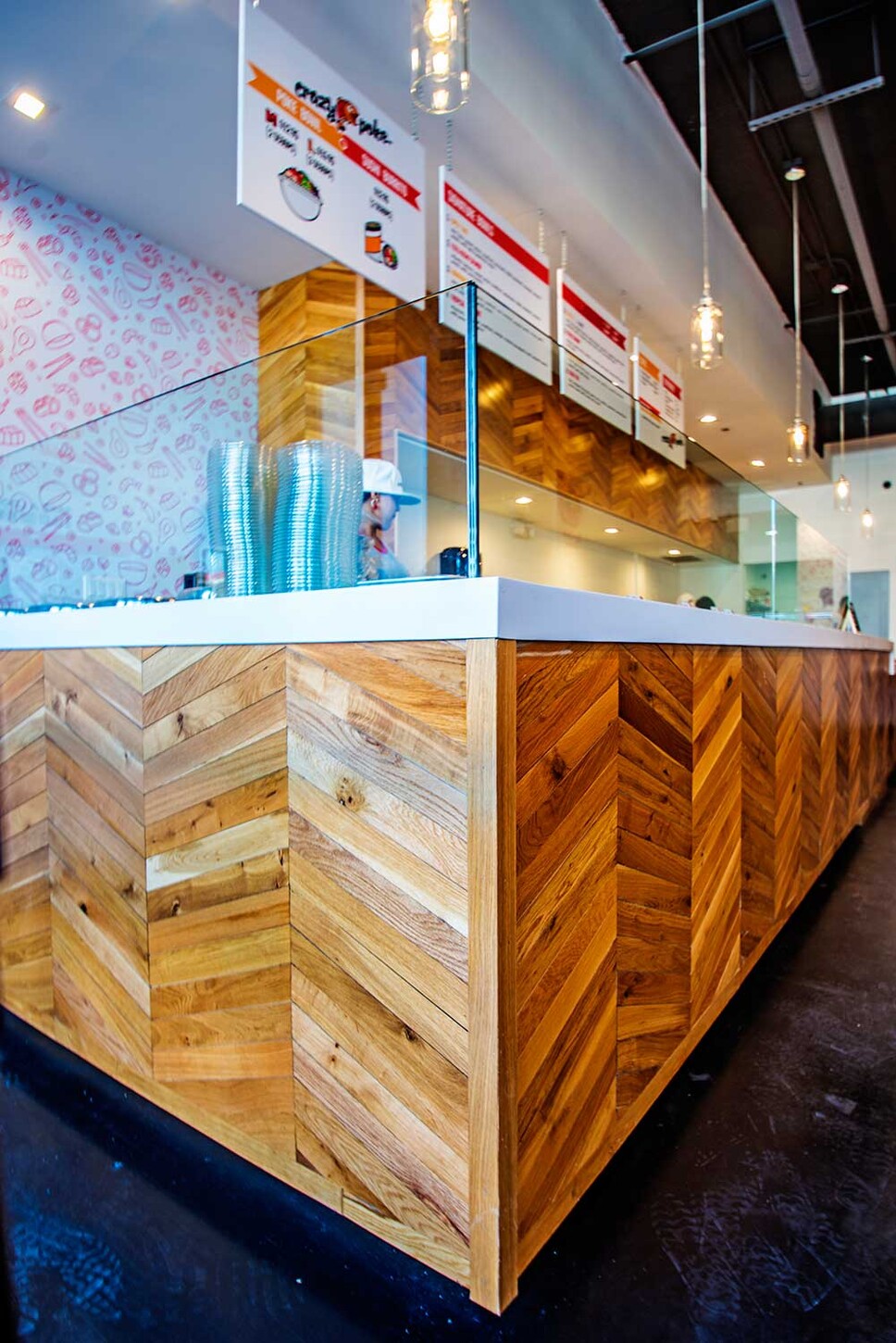Wynwood restaurant millwork: wood service counter with glass divider and chevron front panel